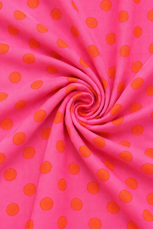 Pink and orange polka dot printed fabric with textured woven surface