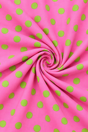 Pink and green polka dot fabric close up texture
