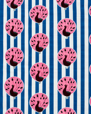 Close-up of pink peacock motifs on blue and white striped printed cotton fabric