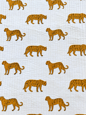 leopard print quilted fabric with black spots on a white background.