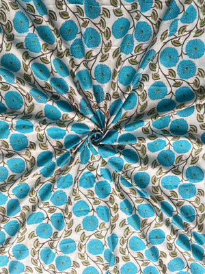 White cotton fabric with blue flowers and green leaves