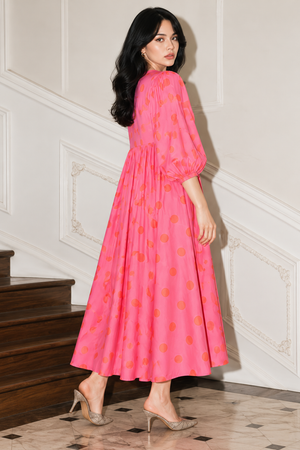 Pink polka dot dress featuring long puff sleeves and elastic cuffs