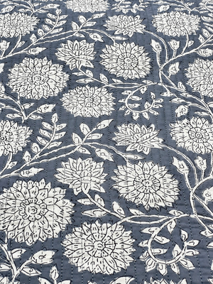 Grey floral quilted fabric with white flowers and black botanical outlines.