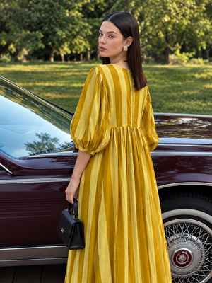 Women's mustard maxi dress featuring vertical stripes and flowing skirt