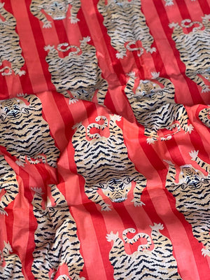 Red cotton fabric with repeating tiger print
