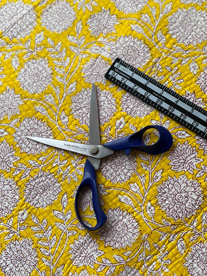 Yellow floral quilting material with decorative stitched diamond texture.