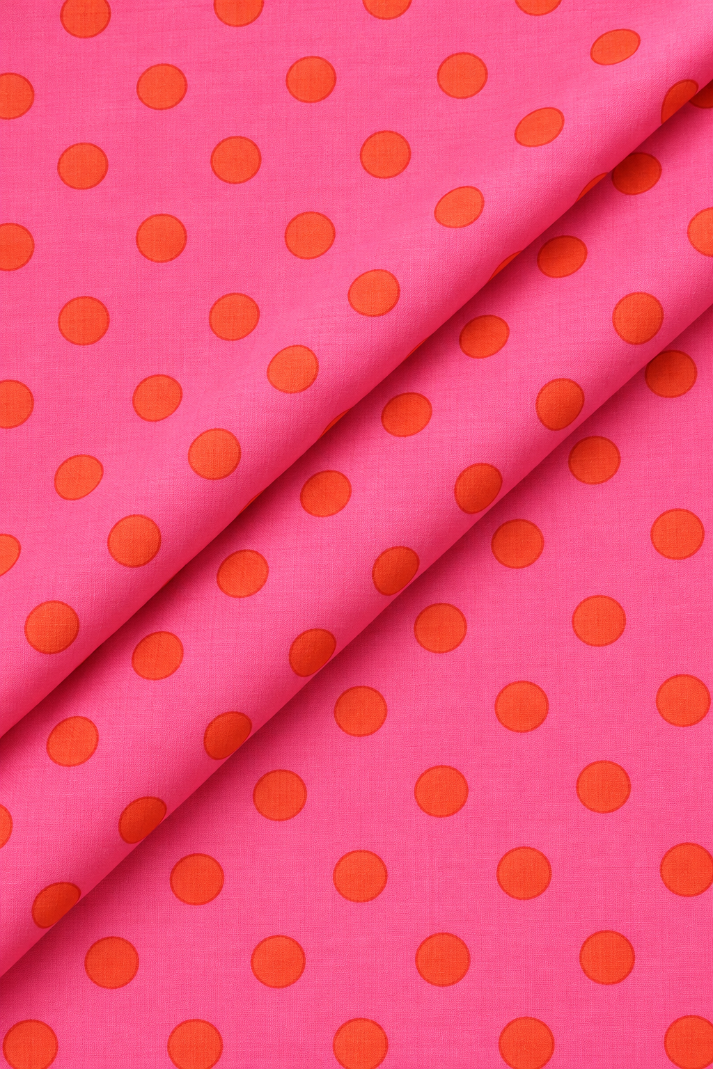 Bright pink dressmaking fabric with evenly spaced orange polka dots