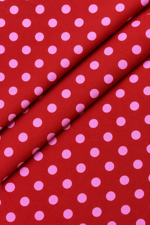 Red and pink polka dot fabric close up texture