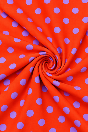 Orange red fabric with purple dot print