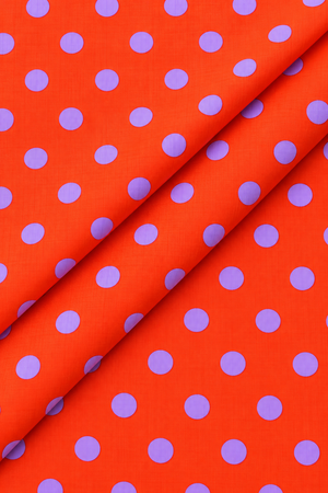 Purple polka dot pattern on bright orange fabric