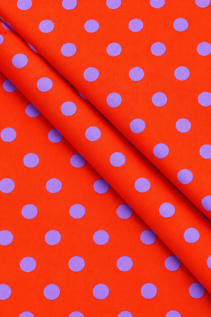 Orange fabric with evenly spaced purple dots