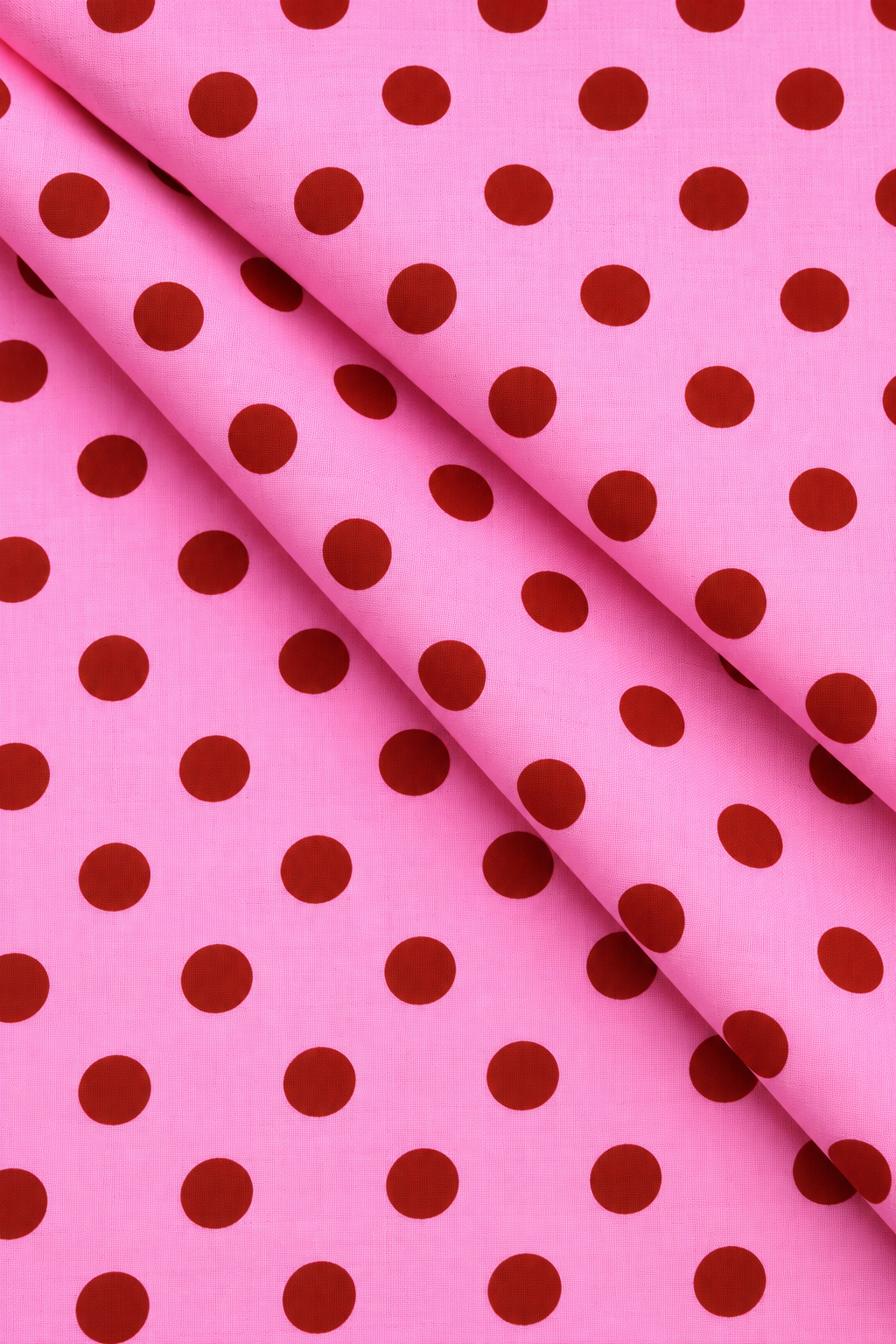 Bright pink printed fabric with a classic dark red dotted pattern