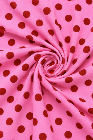 Close-up of pink polka dot printed fabric with visible textile texture