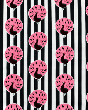 Close-up of pink peacock motifs on black and white striped printed cotton fabric