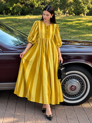 Mustard striped summer dress styled with black heels and handbag