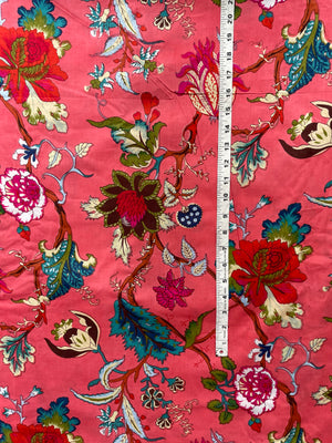 Vibrant pink cotton fabric with colorful flowers and vines