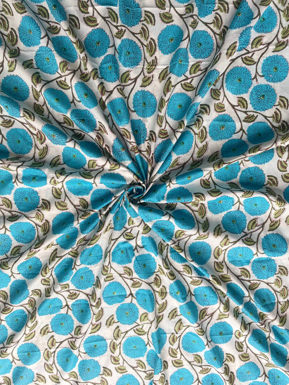 White cotton fabric with blue flowers and green leaves