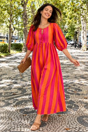 Bright striped boho dress styled with tan sandals and woven clutch