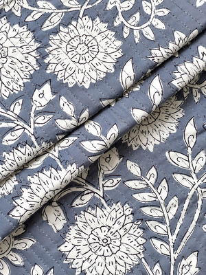 White botanical flowers and leafy vines printed on grey quilted fabric.