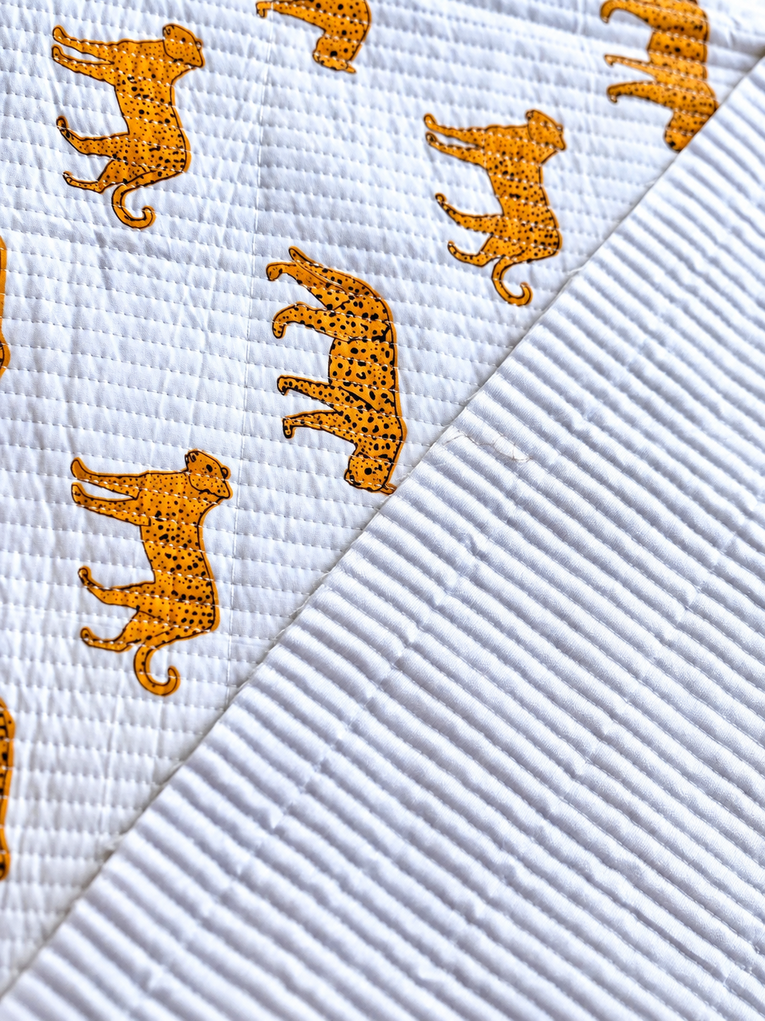Close-up of golden animal print fabric with visible quilted stitching.