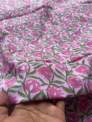 Pink cotton fabric with flowers and green leaves