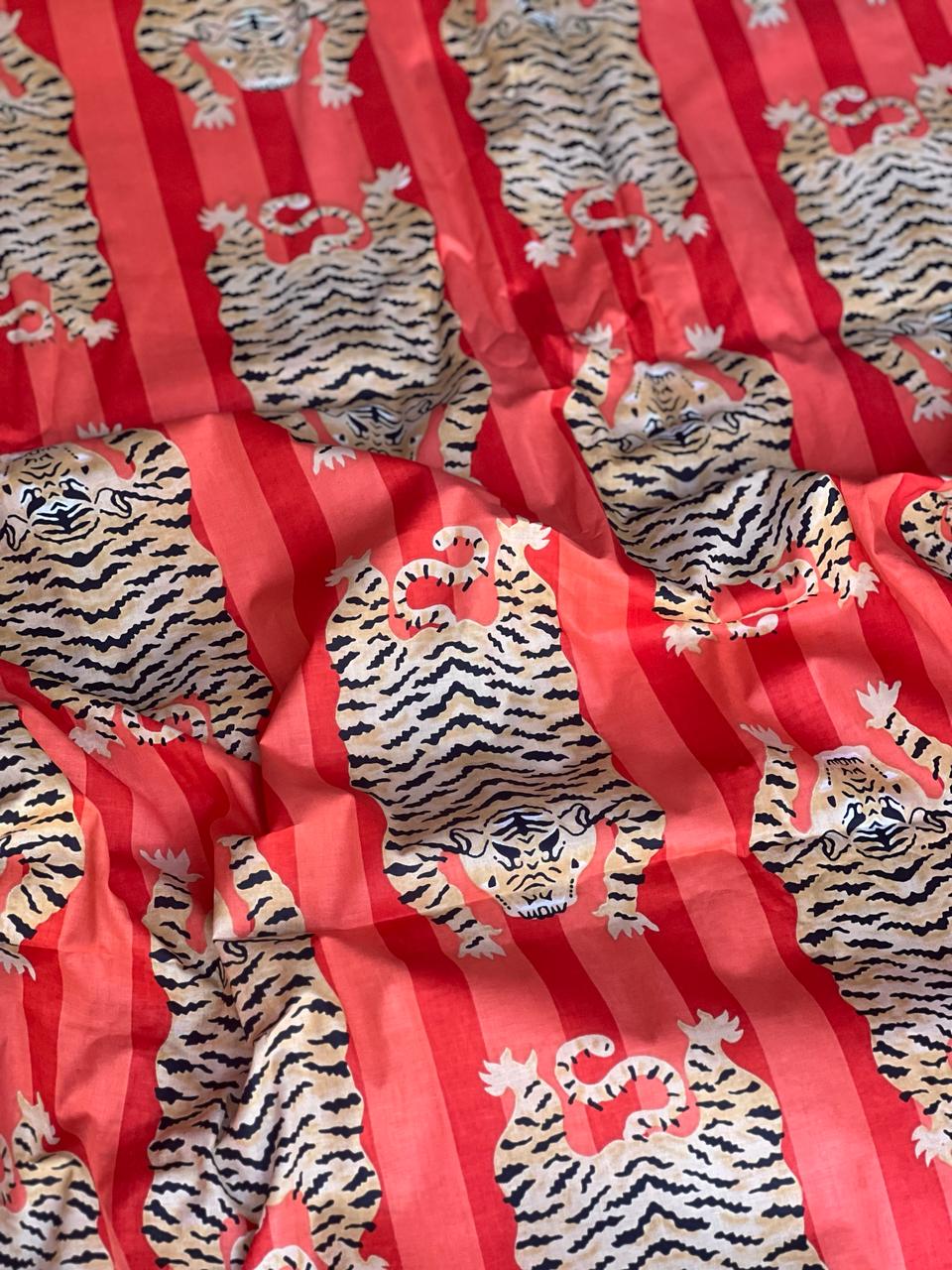 Red cotton fabric with repeating tiger print
