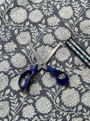 Textured grey floral fabric featuring large blossoms and intricate black detailing.