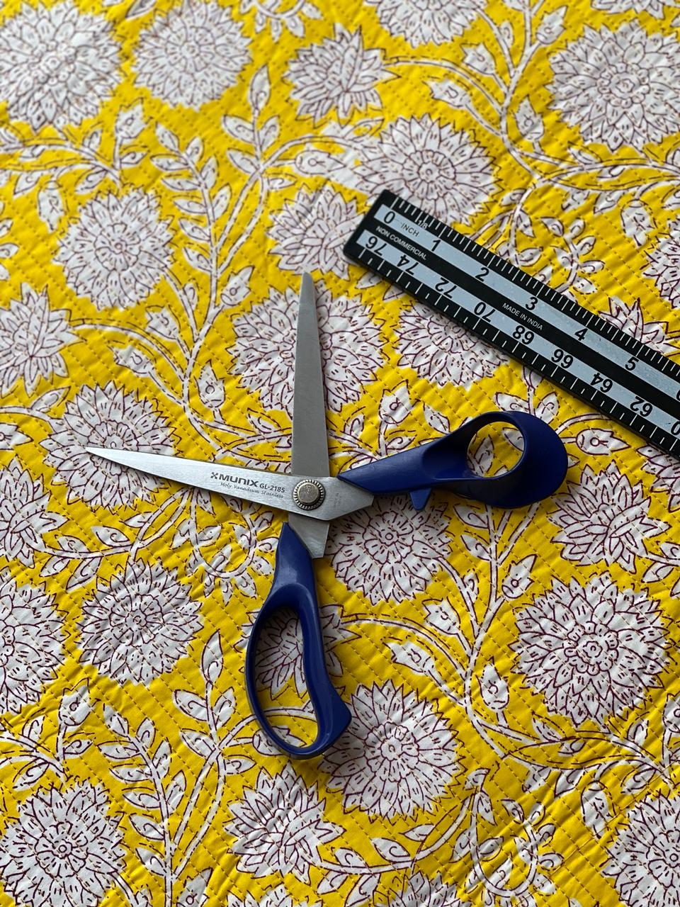 Yellow floral quilting material with decorative stitched diamond texture.