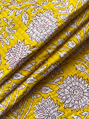 Textured mustard yellow fabric with large white blossoms and burgundy detailing.