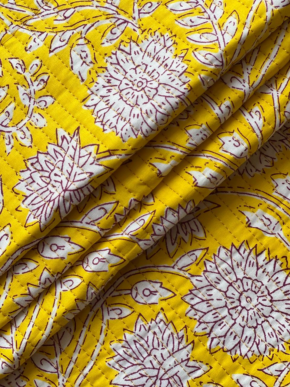 Textured mustard yellow fabric with large white blossoms and burgundy detailing.