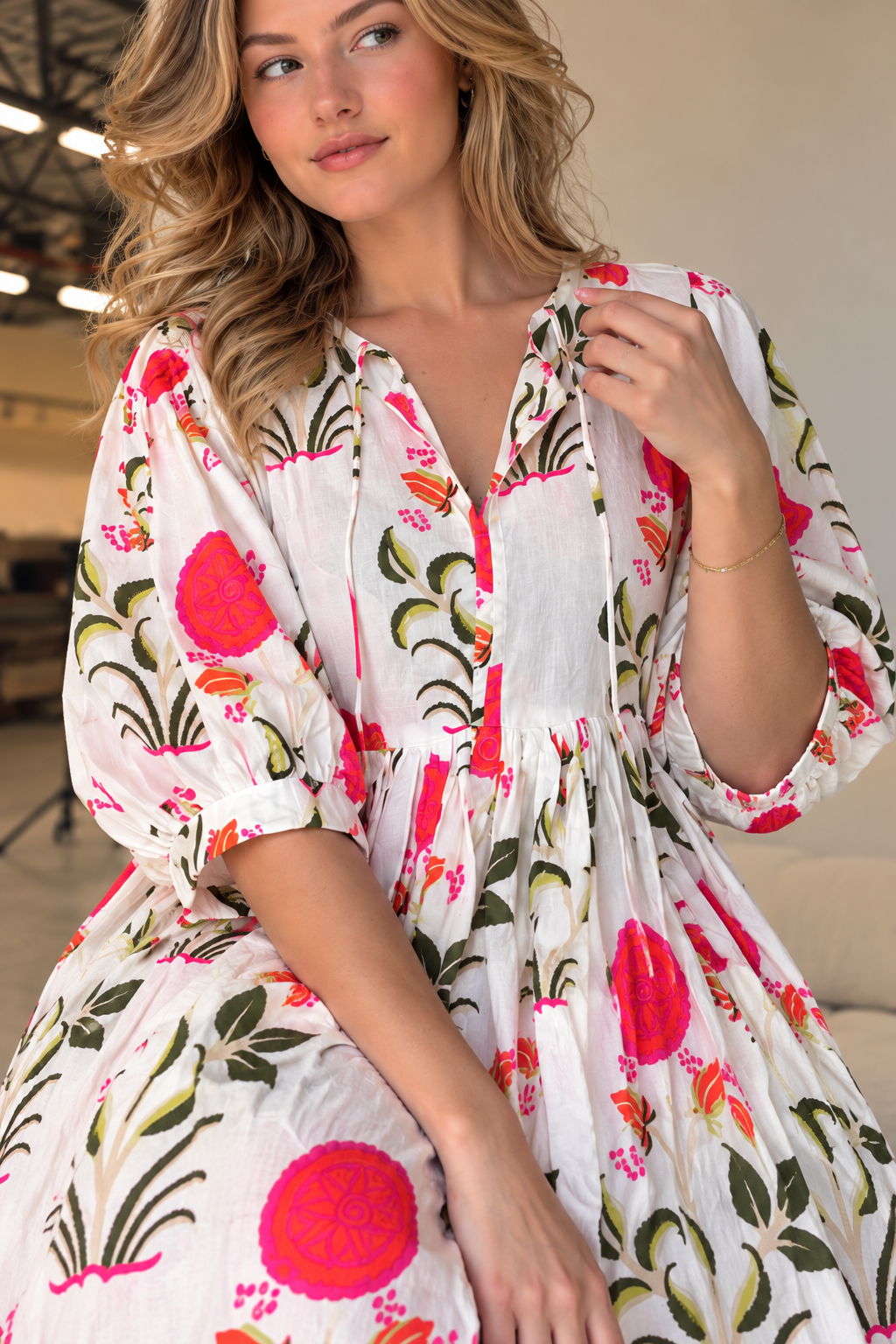 Full-length white maxi dress featuring vibrant pink floral patterns