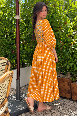 Women's orange maxi dress with empire waist and flowing skirt